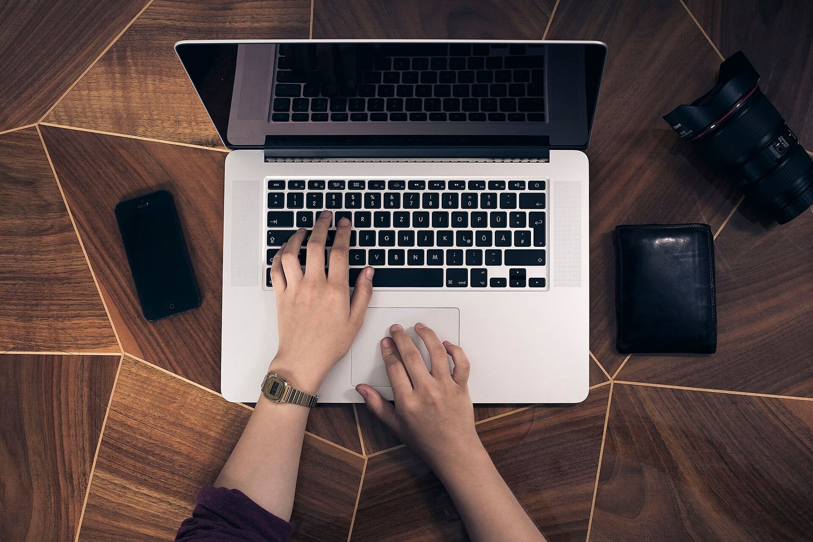 Hands typing on a laptop keyboard