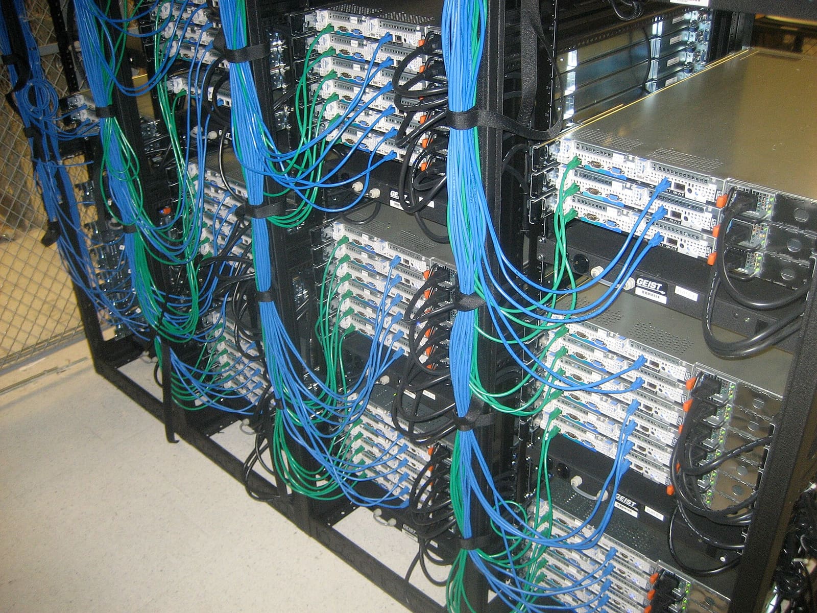 Rows of rack servers wired with blue and green network cables