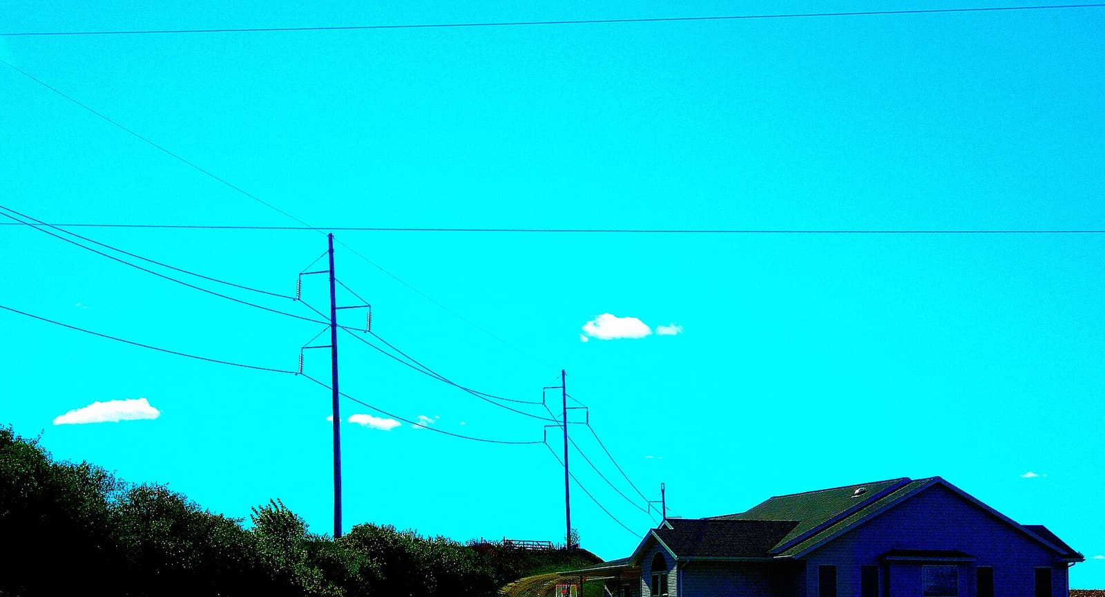 High-voltage transmission towers carrying power lines across open land