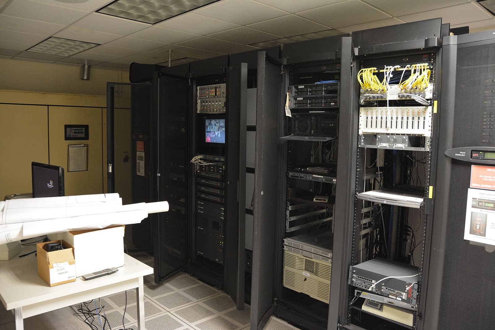 A row of server cabinets with blinking lights in a dark room