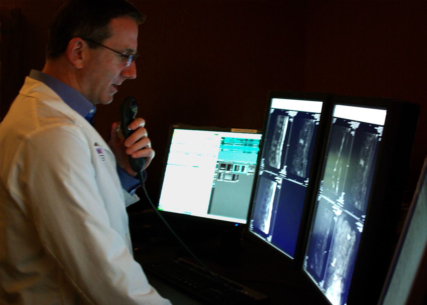A radiologist reading medical images on several monitors
