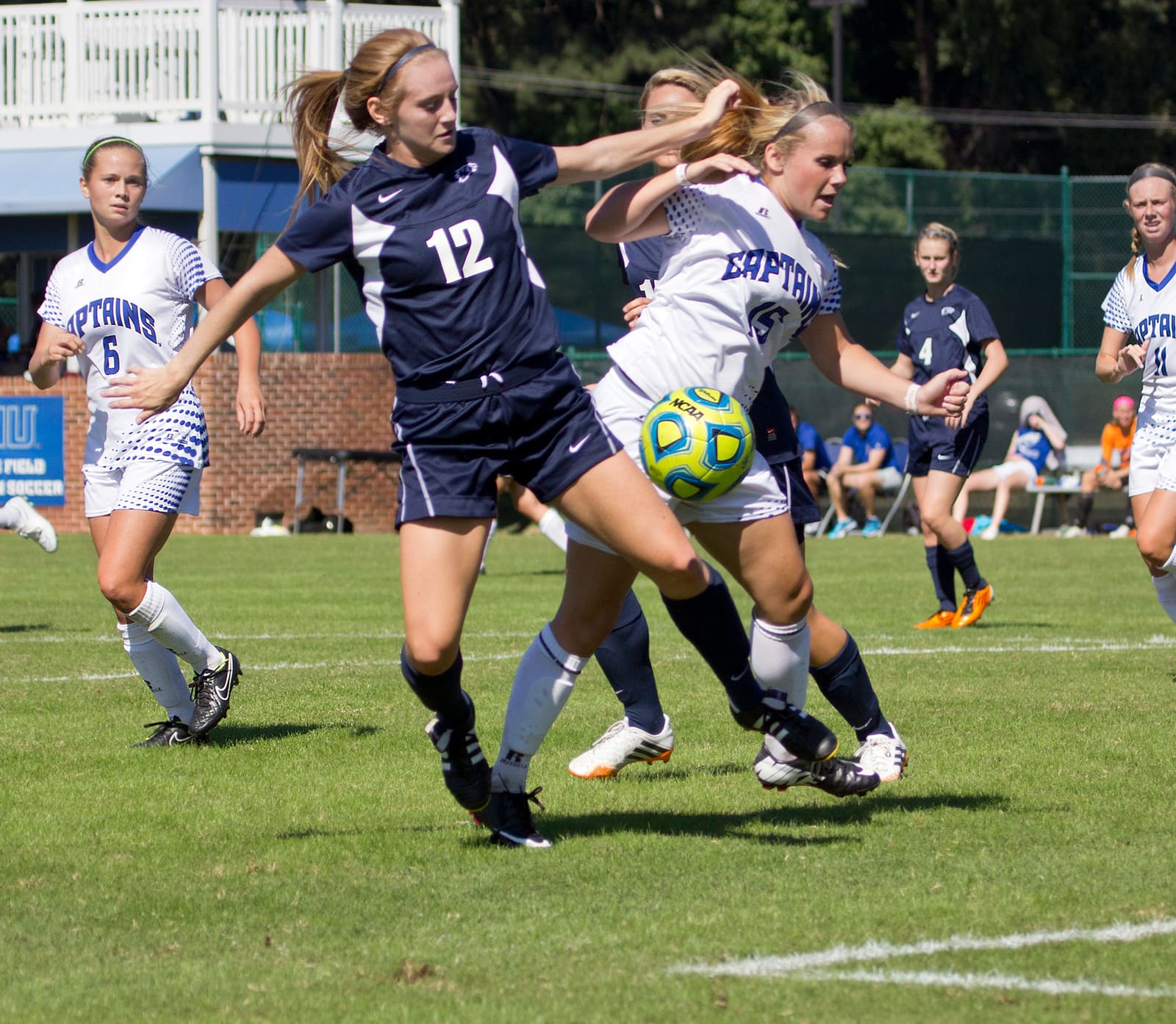 College women's soccer players chasing the ball during a match