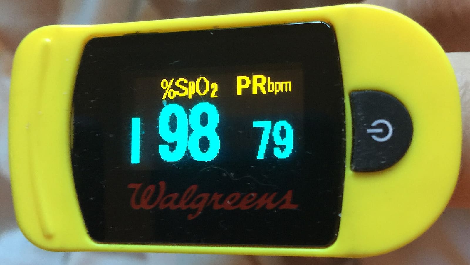 A fingertip pulse oximeter showing heart rate and blood oxygen readings
