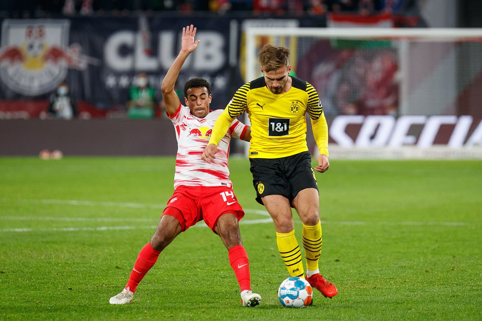 Two soccer players challenging for the ball during a Bundesliga match